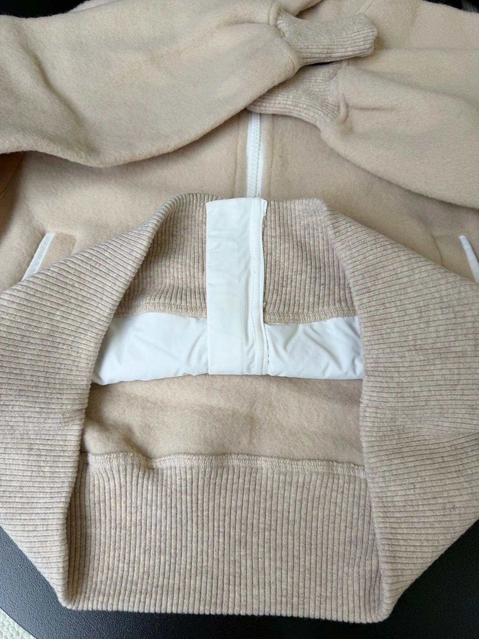 P660 Canada Goose Fleece Wool Badge Hooded Jacket Fabric selection: Wool fleece fabric blended with wool as the main body and a very small amount of spandex and polyester fiber. Wool is a core natural ingredient that provides unparalleled temperature regulation, antibacterial and anti-odor properties and a skin-friendly feel. The feeding of a small amount of spandex gives the fabric a certain degree of four-way elasticity, making it non-restrictive during daily activities. As the basis of fleece's structure, polyester fiber enhances the fabric's durability, wrinkle resistance and quick-drying properties. It contributes to the loft of the fleece and provides functions such as trapping air.  Detail 1: The sleeves and hem are closed with 2×2 ribbing. Its strong elasticity can closely fit wrists and waists of different thicknesses, forming an effective 'seal' to prevent cold wind from blowing back. It can still maintain its original shape after repeated stretching and use, and is not easy to loose and deform. And the ribbed cuffs can convey a sense of design and enhance the visual beauty.  Detail 2: The combination of hood design and elastic buckle improves warmth and windproof performance when wearing. Accessories: Customized elastic drawstring, elastic buckle, custom zipper pendant, custom armband Size: S M L Color: black gray coffee rice pink
